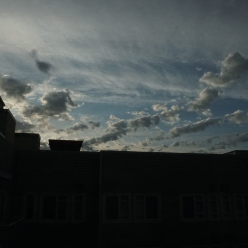 Photo of overcast skies with a building silhouette.
