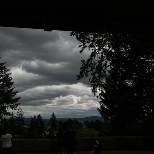 Photo of thick, multi-layered rain clouds over Downtown Portland as seen from the Portland Japanese Garden.