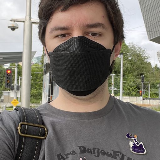 Selfie taken while wearing a Kumoricon staff shirt and waiting for a bus at the TriMet S Waterfront/S Moody station.