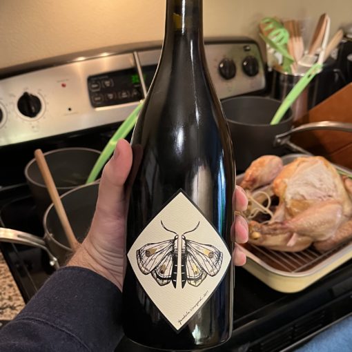 Photo of a bottle of a 2017 Yamhela Pinot Noir from Battle Creek Cellars with Thanksgiving food items in the background.