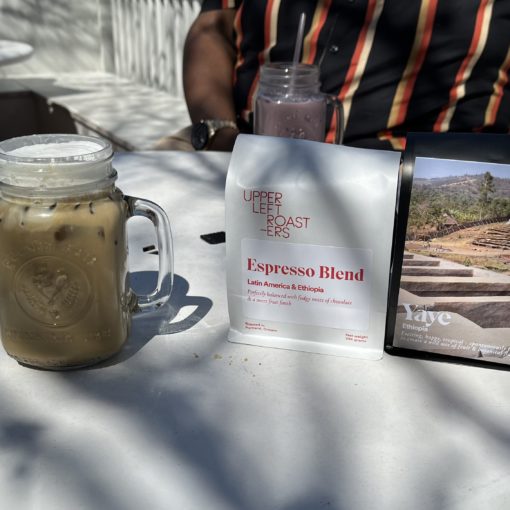 Photo of two bags of coffee and an iced hojicha latte from Upper Left Roasters in Ladd's Addition.