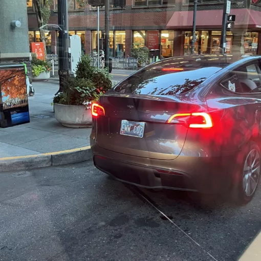 Photo of a Tesla with a license plate reading "EWW C02".