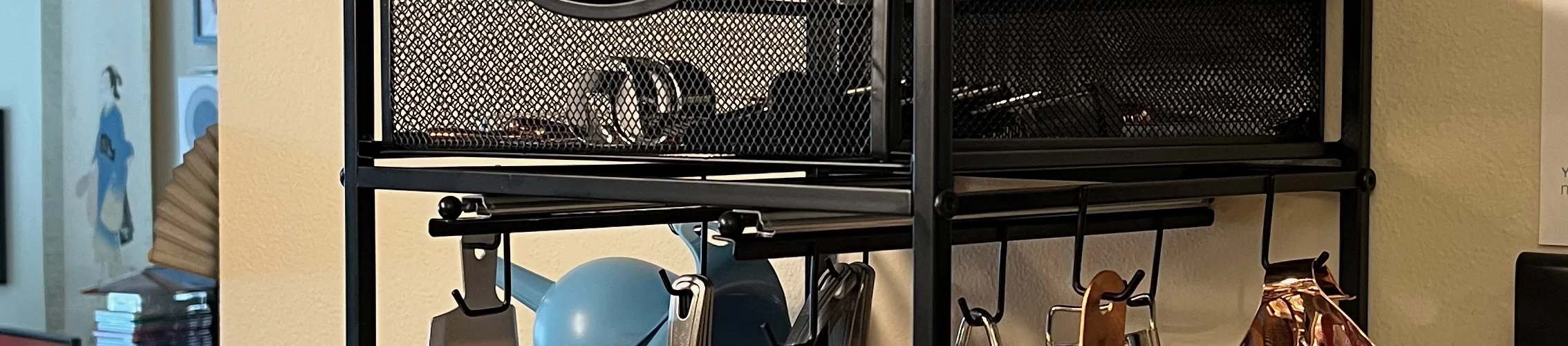 Photo of a kitchen organizer hung on the wall above an espresso machine.