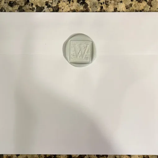 Photo of the backside of a Christmas card envelope showing a wax seal with a "W" imprint.