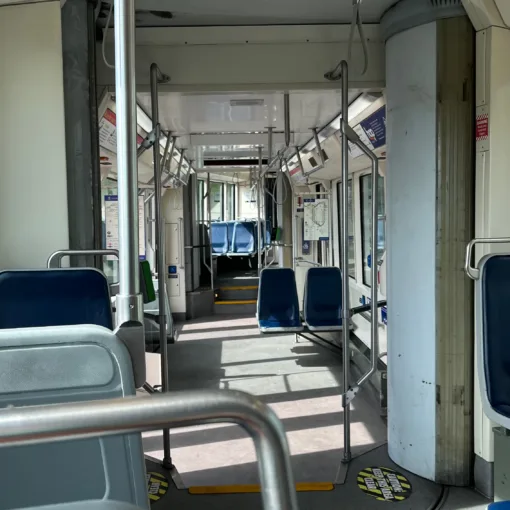 Photo of the interior of Portland Streetcar 002 showing an empty train as it departs from S Lowell & Bond.